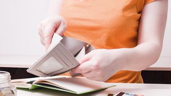 Person sitz mit einer leeren Geldbörse zu dem Thema Anti-Teuerungspaket