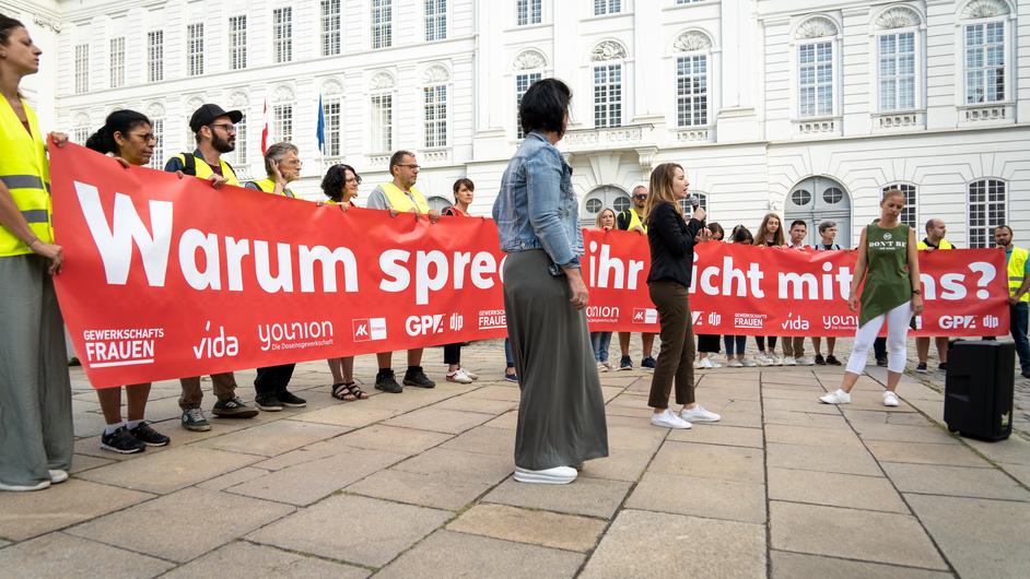 Menschenmenge mit langem Transparent, mit dem Text "Warum sprecht ihr nicht mit uns?"