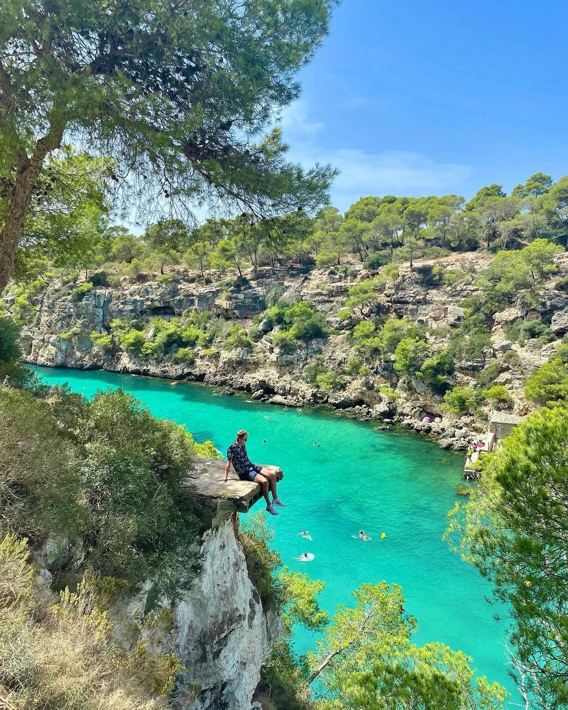 Bucht, wobei ein Mann weiter oben auf einen Vorsprung sitzt!