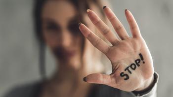Frau mit einer ausgestreckten Hand auf der Stopp steht